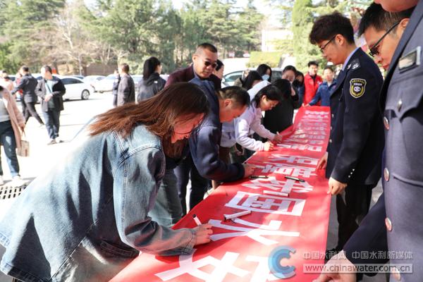 三门峡水利枢纽景区游客在宣传横幅上签字